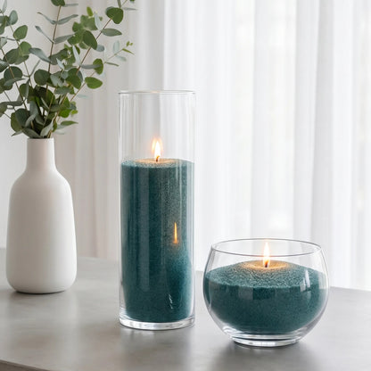 Elegant Glass vases of various heights filled with burning Emerald pearled candle sand creating a glowing cluster