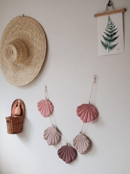 Modern powder pink shell garland hanging in a bright, dreamy nursery