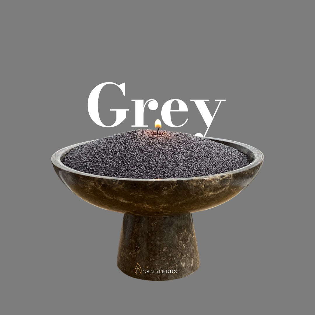 Grey text on a matching elegant grey background with a glass vase full of unlit pearled candle sand in the foreground