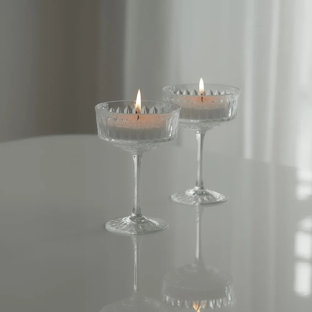Elegant glass filled with Lemongrass Ginger scented pearled candle sand and lit cotton wicks 