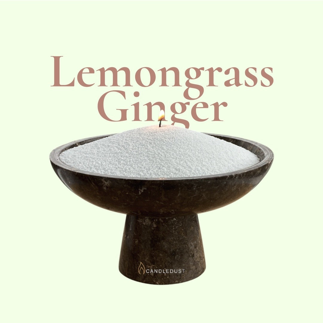Lemongrass Ginger text on a fresh citrus background with a glass vase of unlit pearled candle sand in the foreground