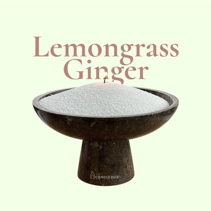 Lemongrass Ginger text on a fresh citrus background with a glass vase of unlit pearled candle sand in the foreground
