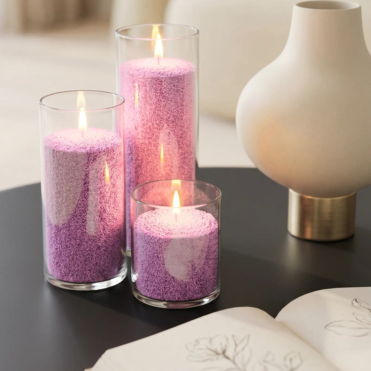Glass vases of various heights filled with burning Lilac pearled candle sand creating a glowing cluster