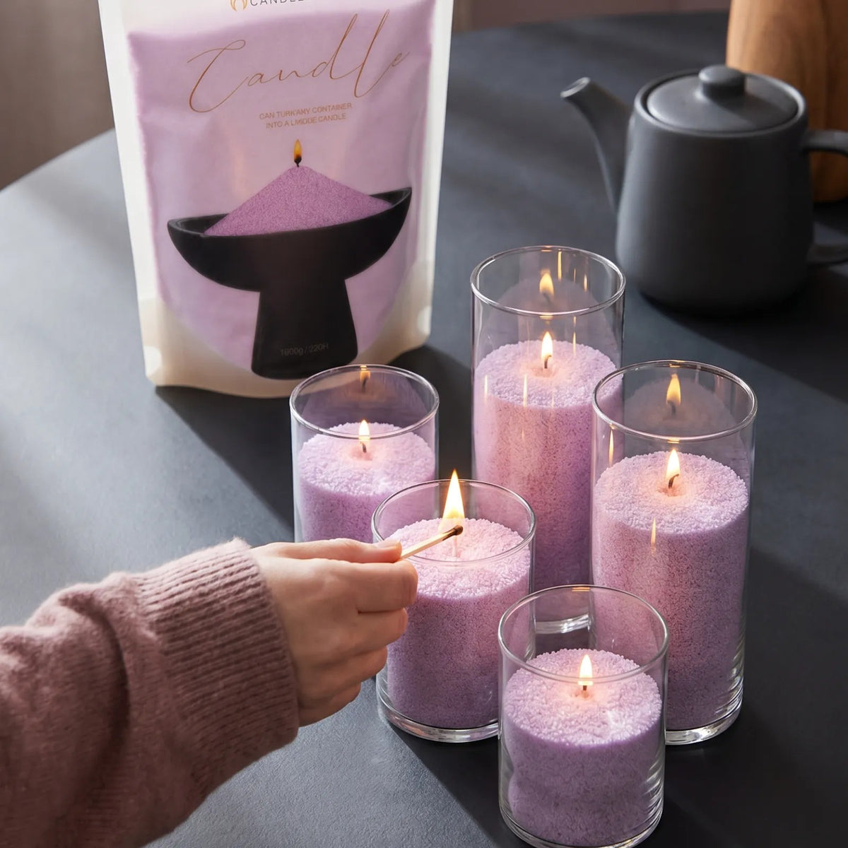 Close-up of a woman's hand lighting the cotton wick of a Lilac pearled sand candle