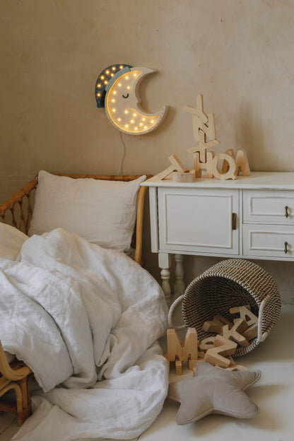 Decorative wooden moon lamp illuminating a dark bedroom