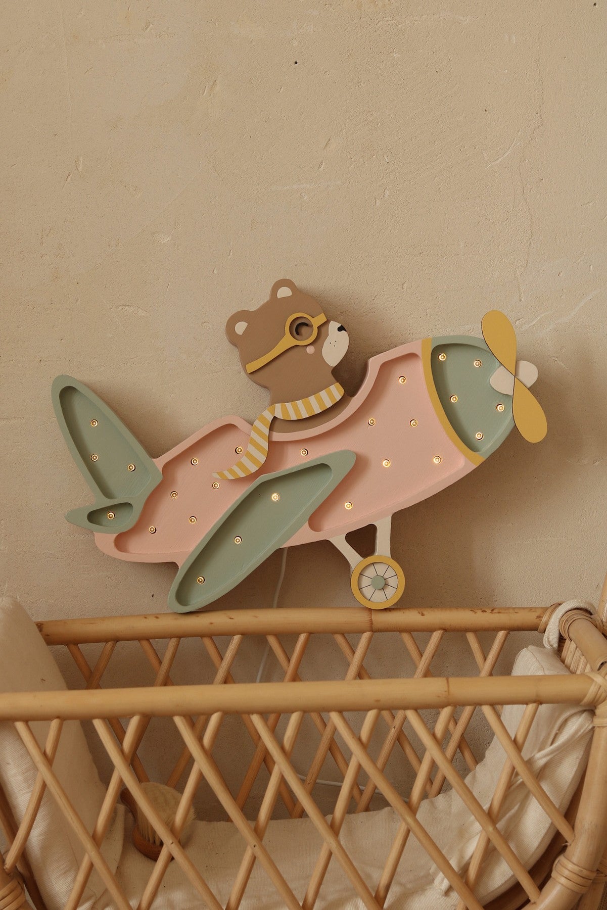 Vintage pink wooden airplane night light for aviation nursery decor.