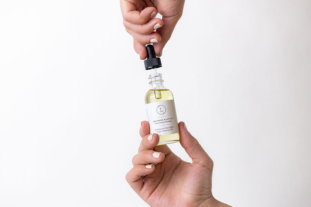 Lavender Body Oil - Woman's hand holding glass dropper bottle of natural body oil | Lizush