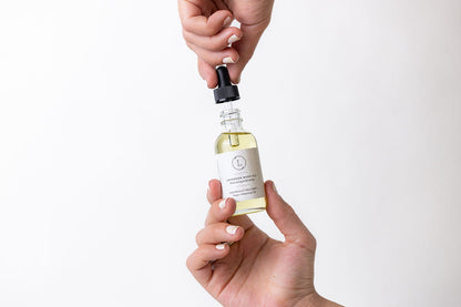 Lavender Body Oil - Woman's hand holding glass dropper bottle of natural body oil | Lizush