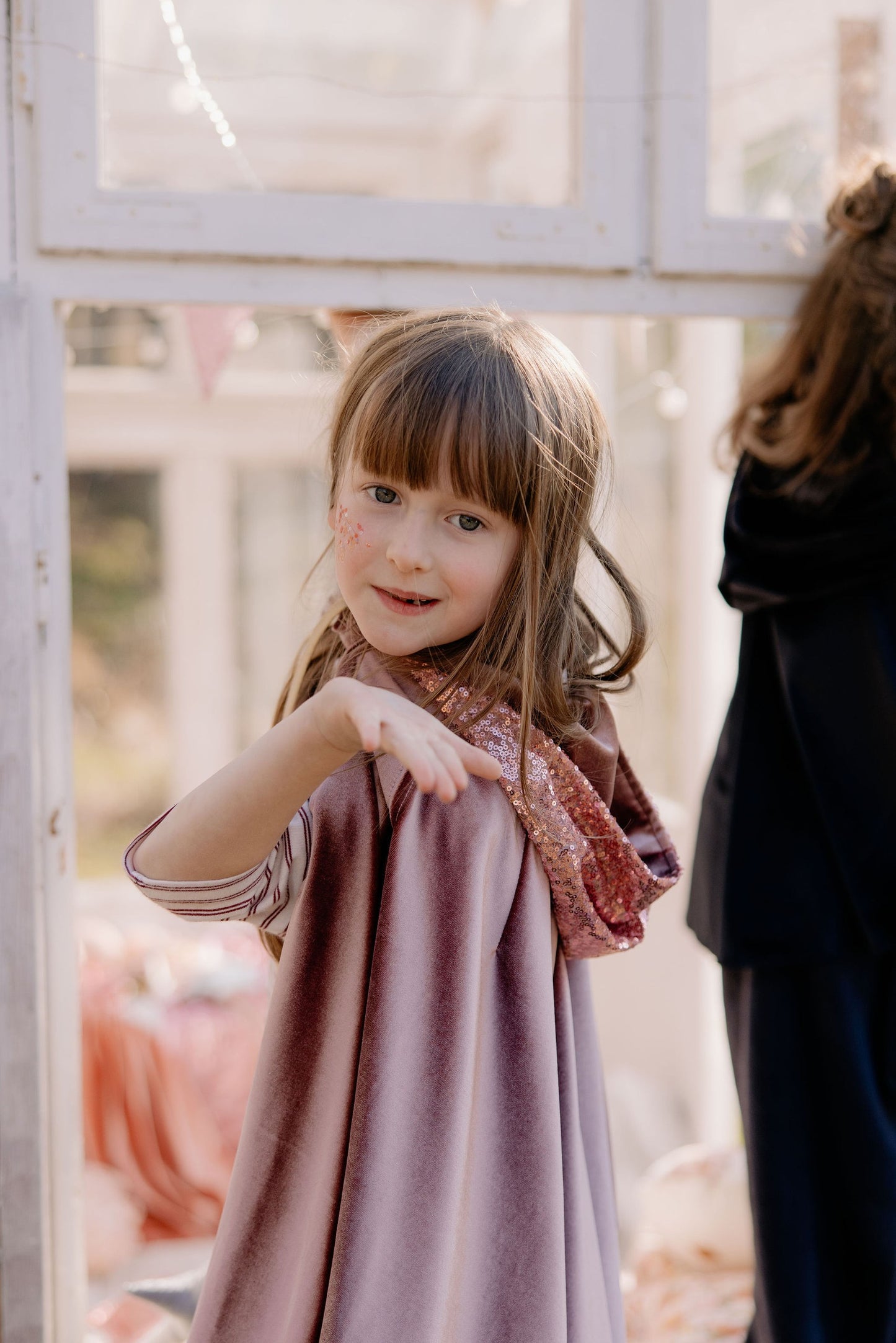 Magical play scene: child in Cosmic Pearl shimmering cape in a Montessori room