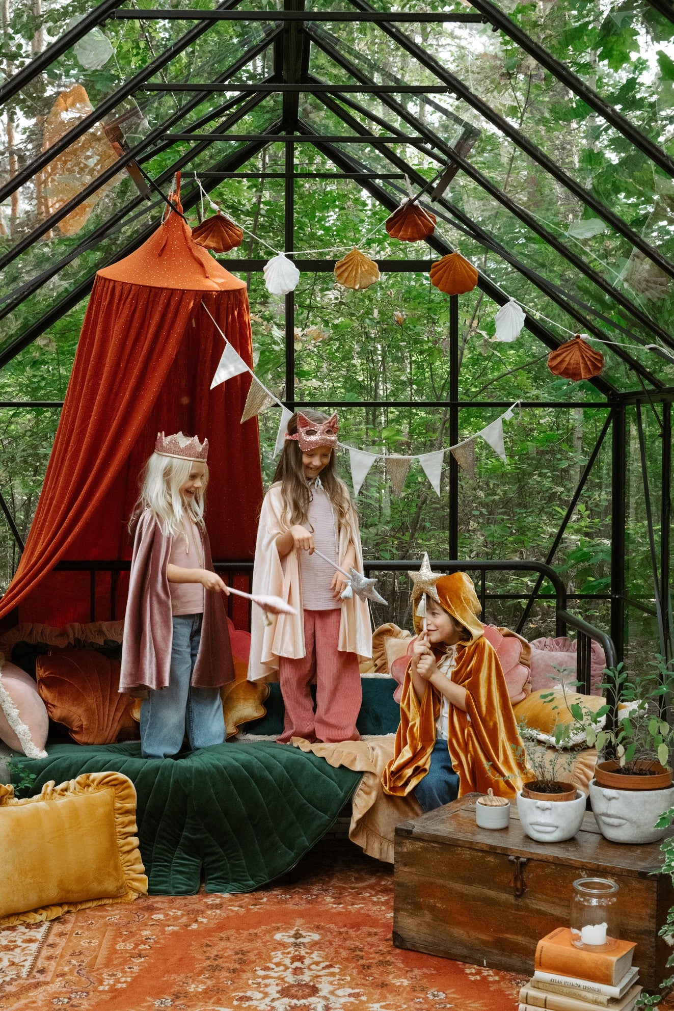 Moi Mili Magic Cape: kids costume party in a glass-walled forest room overlooking tall green trees