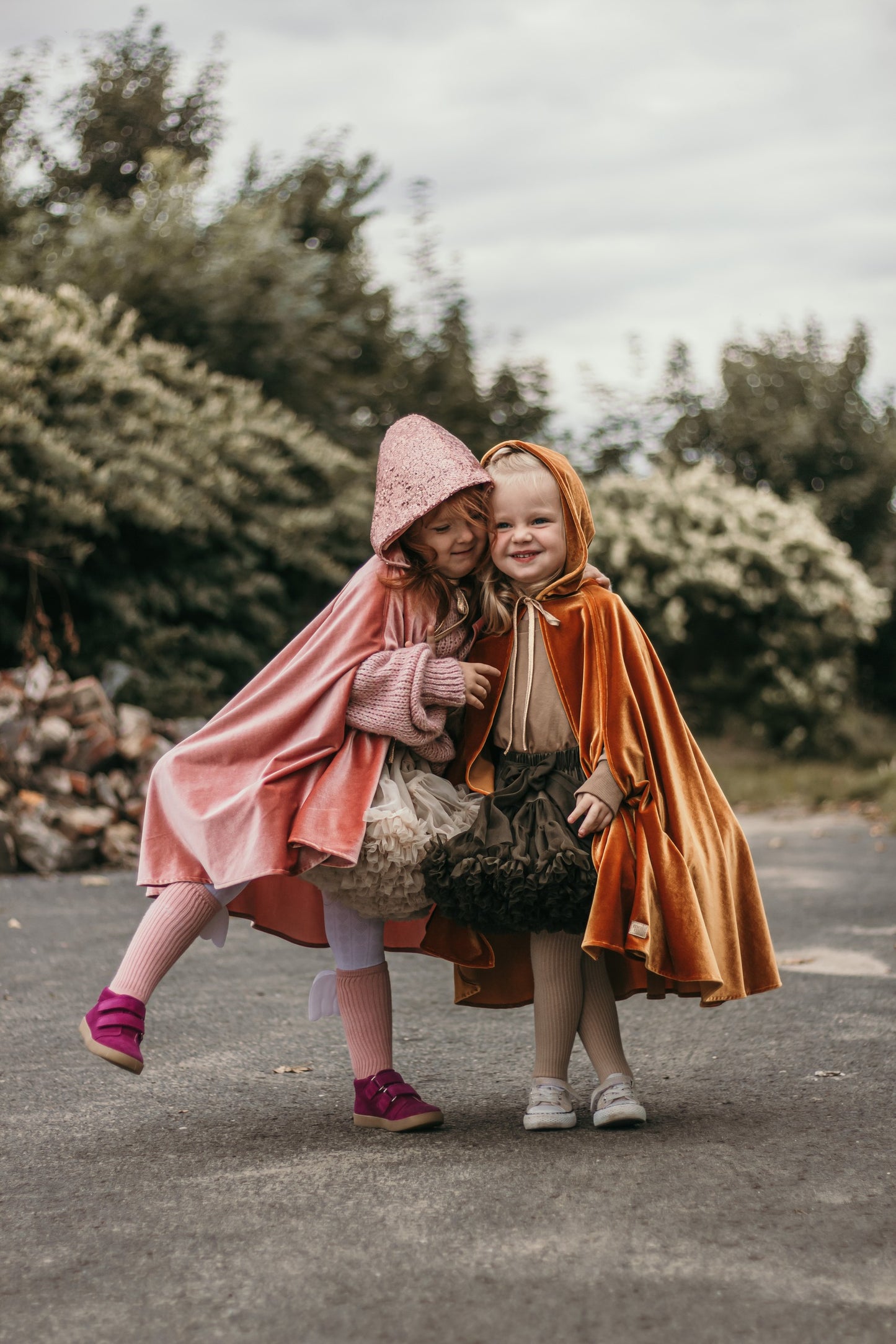 Two Kids outside with Moi Mili Pink Riding Hood Magic Cape - Soft pastel pink velour costume with hood