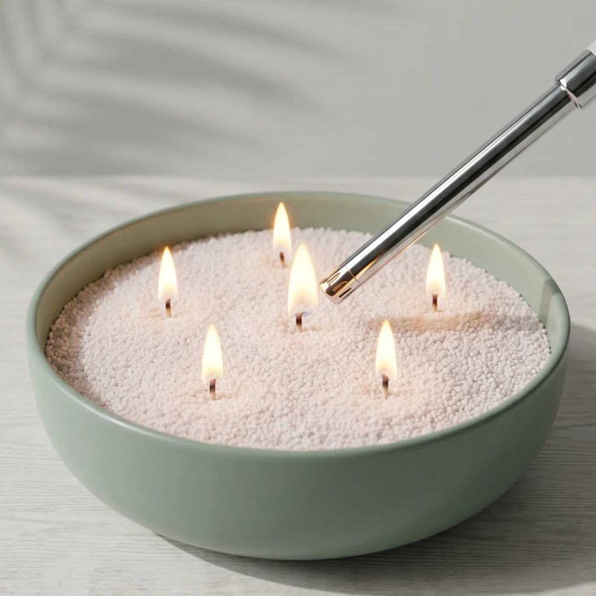 Close-up of hand lighting the cotton wick of a Mango Lime scented pearled sand candle