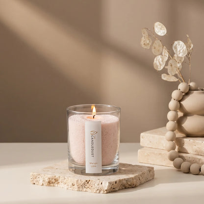 Lit Candledust Mango Lime scented pearled candle in a 160g glass jar sits on a stone slab on a tabletop