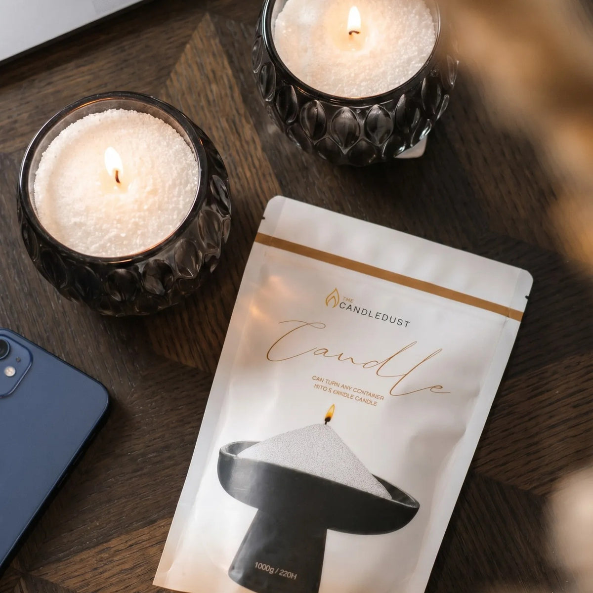 Top view of Lit Midnight scented pearled sand candles resting on a wooden table 