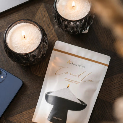 Top view of Lit Midnight scented pearled sand candles resting on a wooden table 