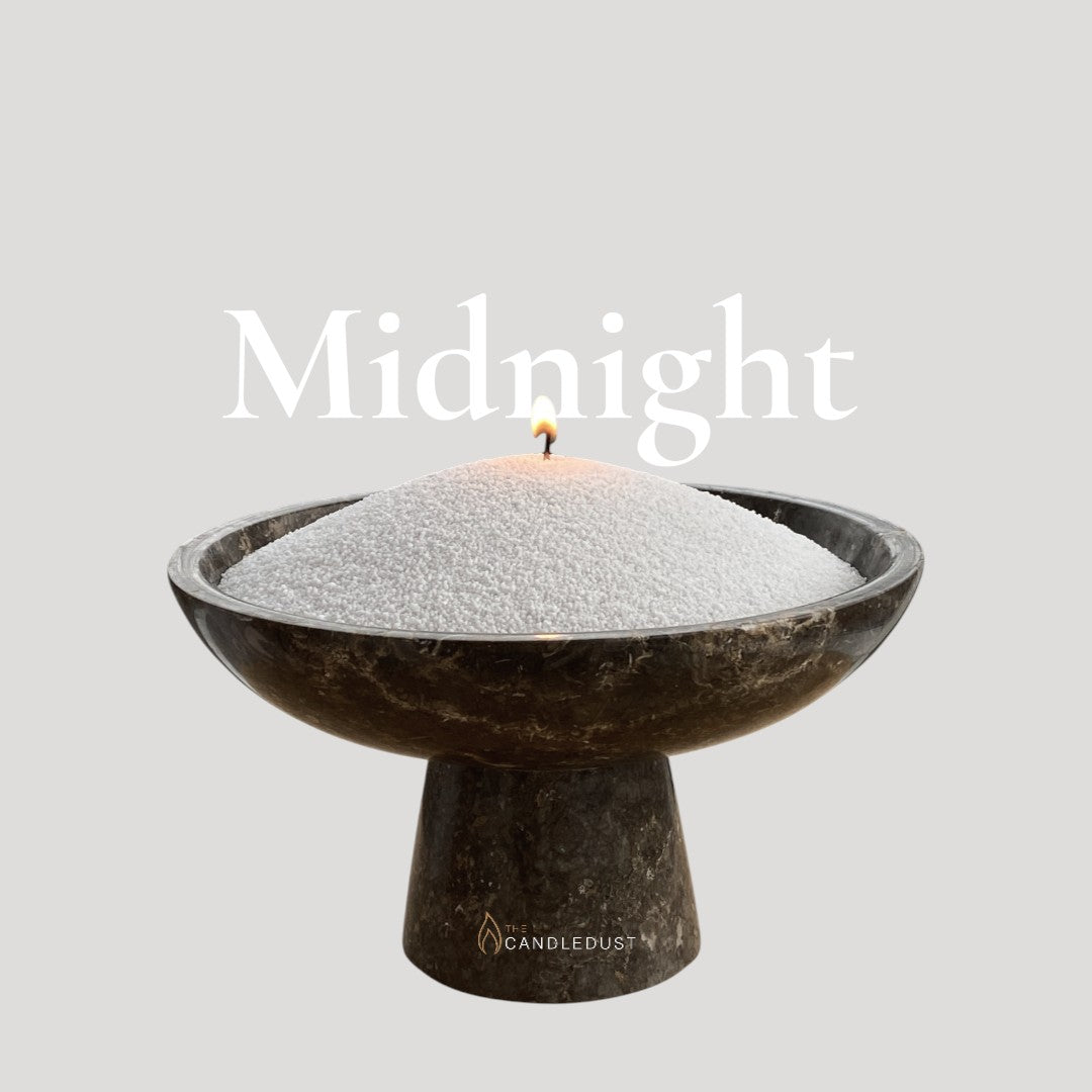 Midnight text on a matching elegant deep midnight background with a glass vase full of unlit pearled candle sand in the foreground