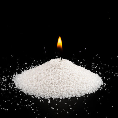 Burning Midnight scented pearled sand candle with a bright flame isolated on a dramatic black background