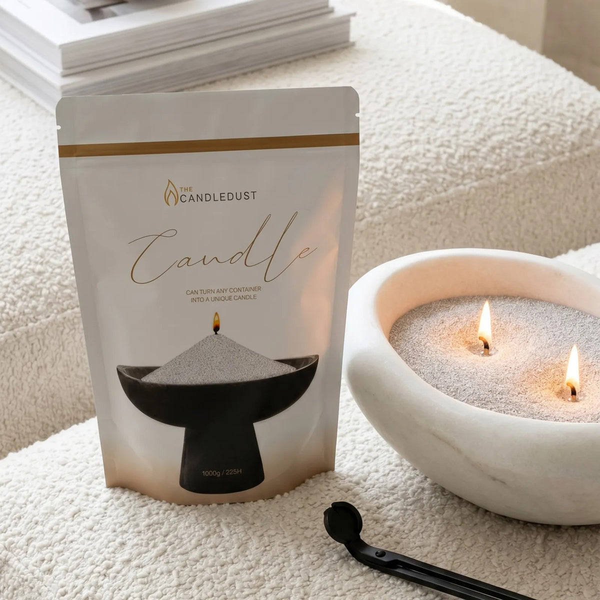 Lit Midnight scented pearled sand candle displayed on a decorative tray resting on elegant sofa