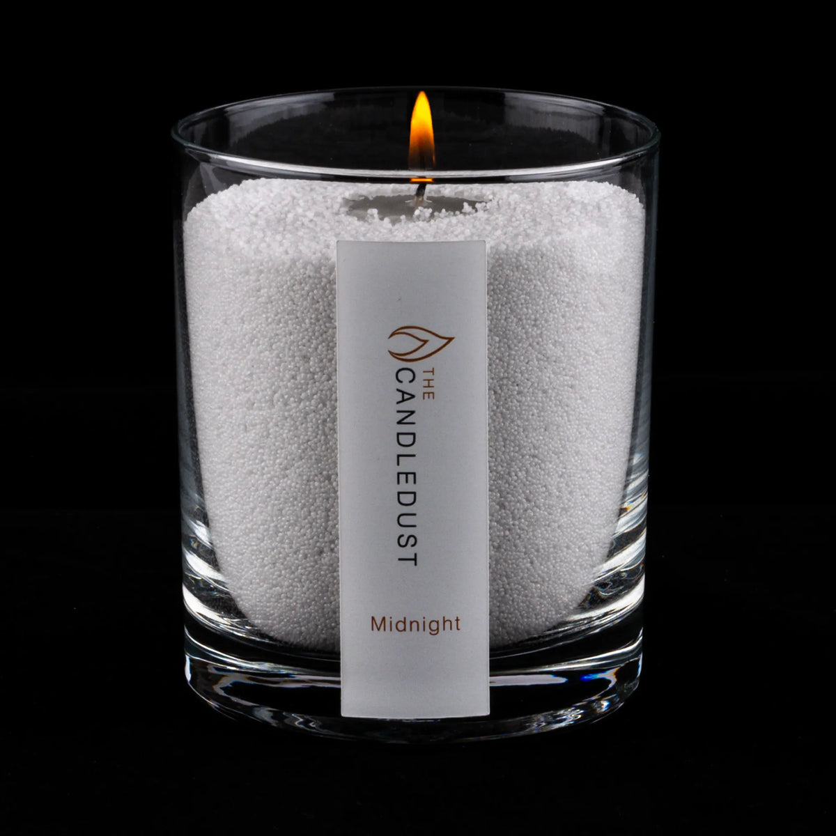 Lit Candledust Midnight scented pearled candle in a 160g glass jar on a black background