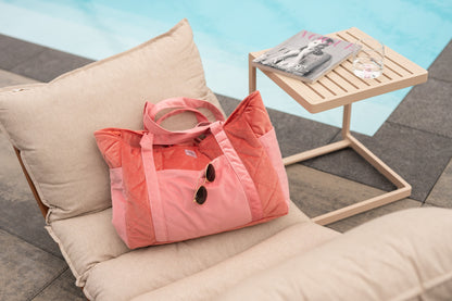 Moi Mili Candy Mom Weekender Bag: pink quilted cotton travel bag resting on a poolside sun lounger