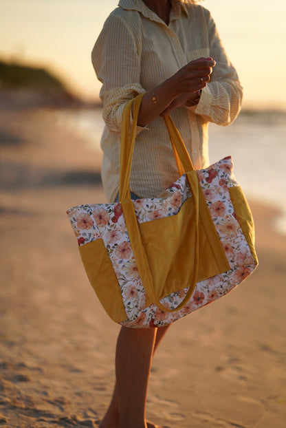 Beach life: a mother holding a sturdy Flower Power cotton travel bag during a family walk by the sea at sunset