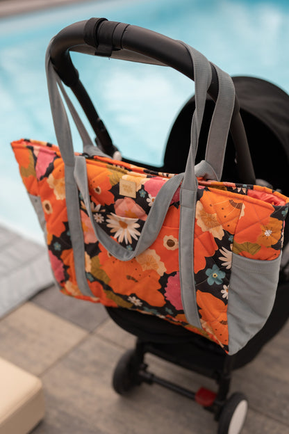 Moi Mili Mom Weekender Bag Picnic With Flowers: large quilted cotton travel bag hanging from a stroller handlebar