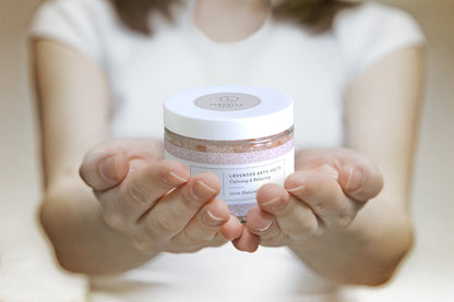 Lavender Bath Salt Soak - Woman's hand holding glass jar of natural lavender bath salts | Lizush