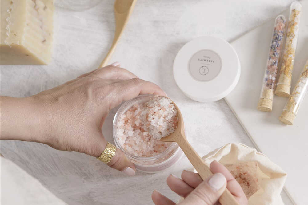 Lavender Bath Salt Soak - Woman scooping natural bath salts from jar with a spoon | Lizush
