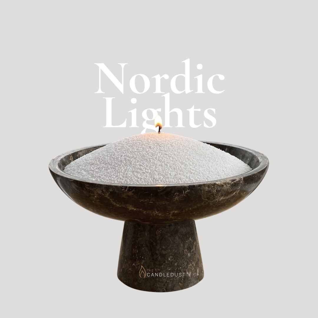 Nordic Lights text on a matching cool glowing background with a glass vase full of unlit pearled candle sand in the foreground