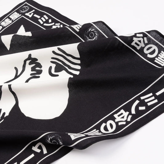 Close-up of soft fabric texture, woven fringe edges, and Moomin Novels illustration