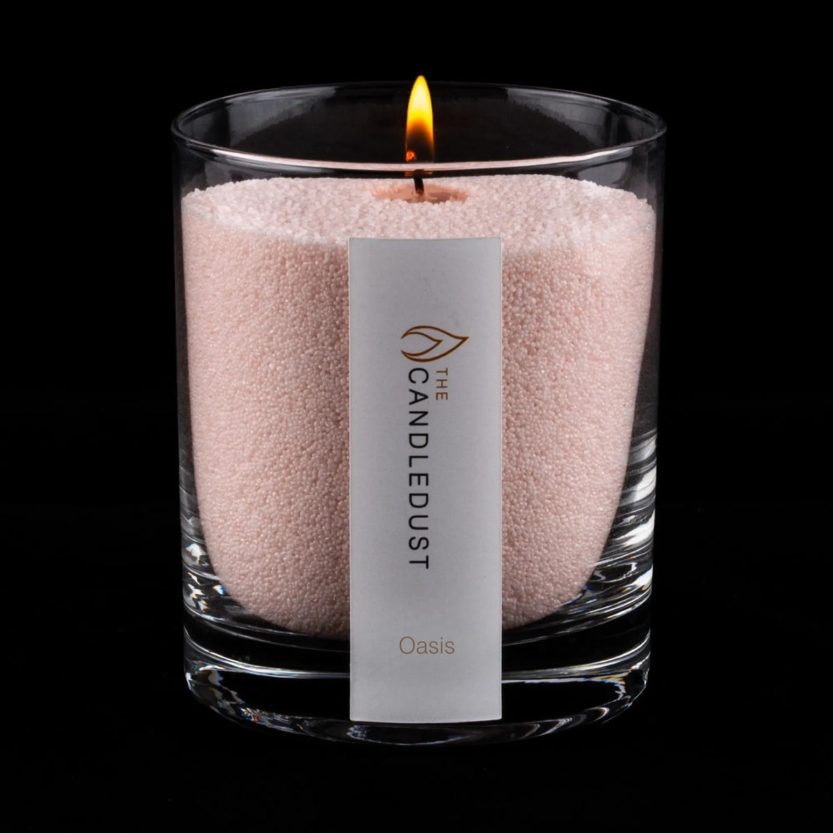 Lit Candledust Oasis scented pearled candle in a 160g glass jar with cotton wick on a black background