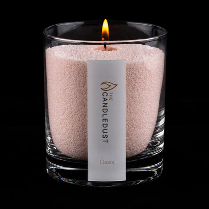 Lit Candledust Oasis scented pearled candle in a 160g glass jar with cotton wick on a black background