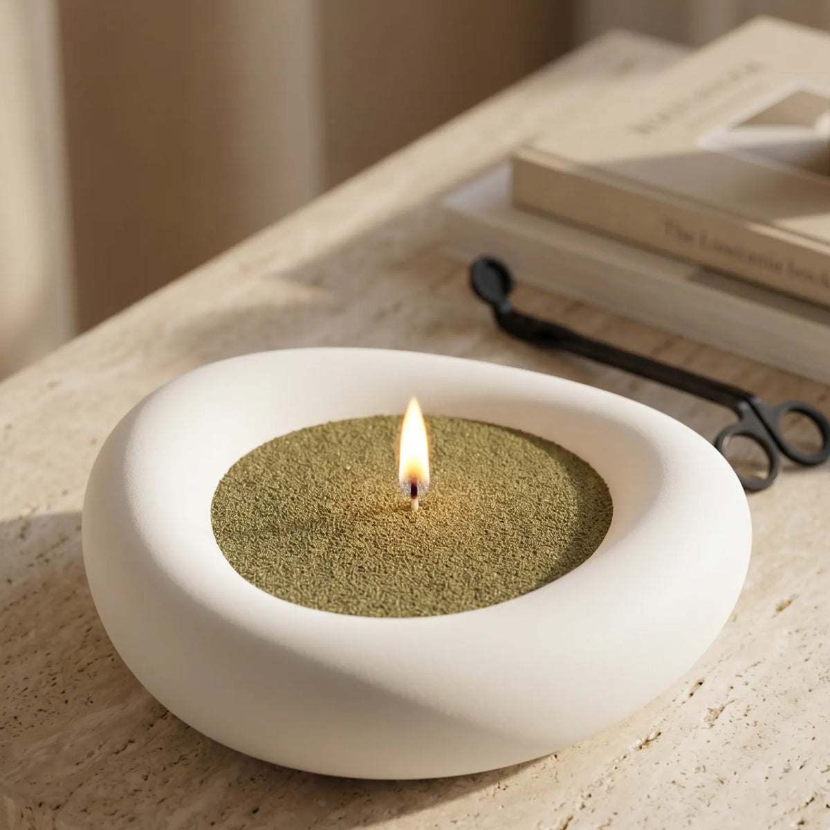 Elegant vase filled with Olive Green pearled candle sand and lit cotton wicks resting on a refined marble countertop