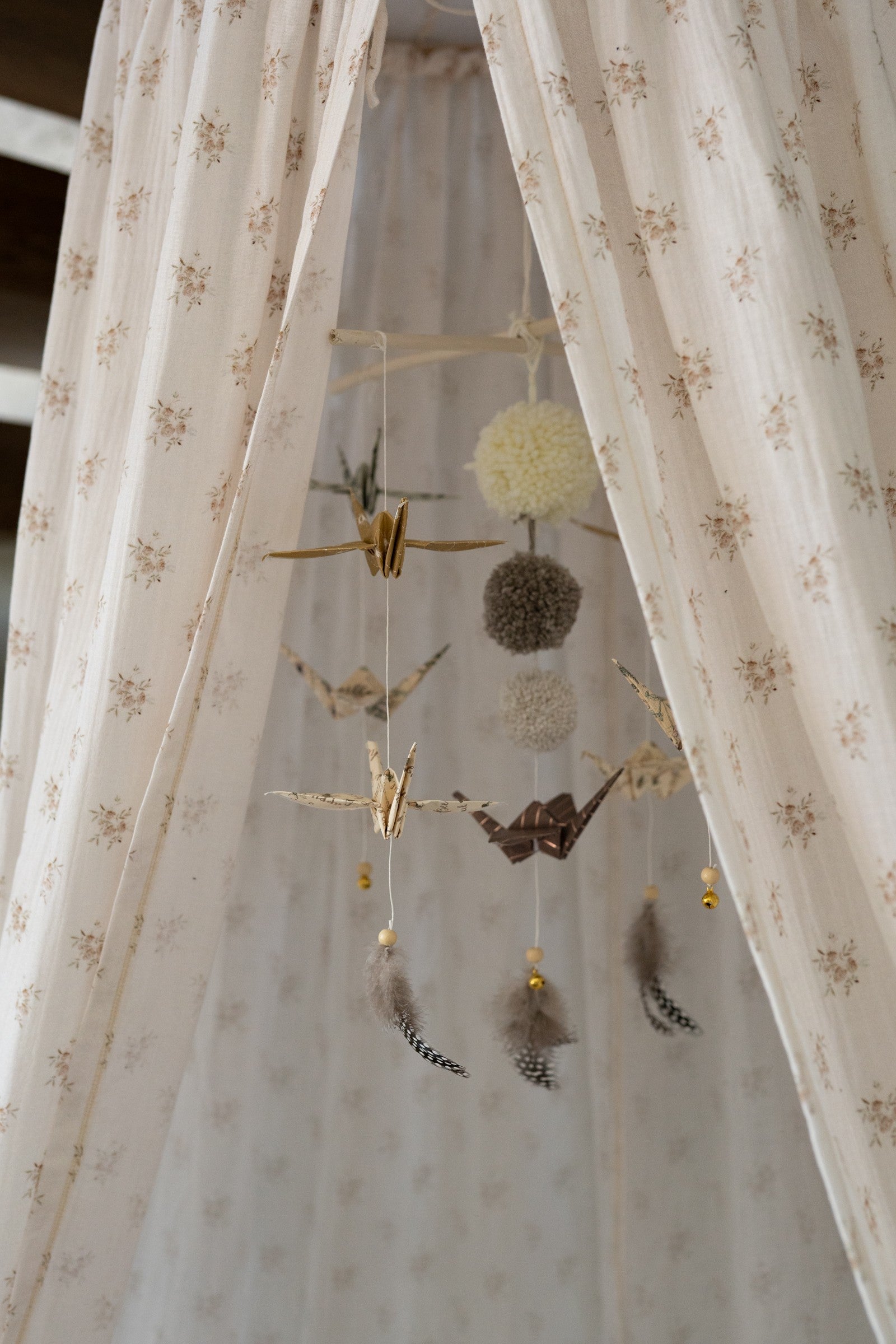 Detailed view of the gold-flecked fabric and origami-inspired folds of the nursery mobile