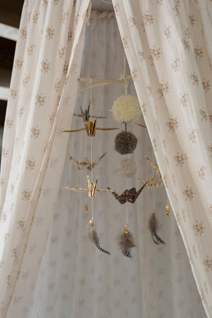 Detailed view of the gold-flecked fabric and origami-inspired folds of the nursery mobile