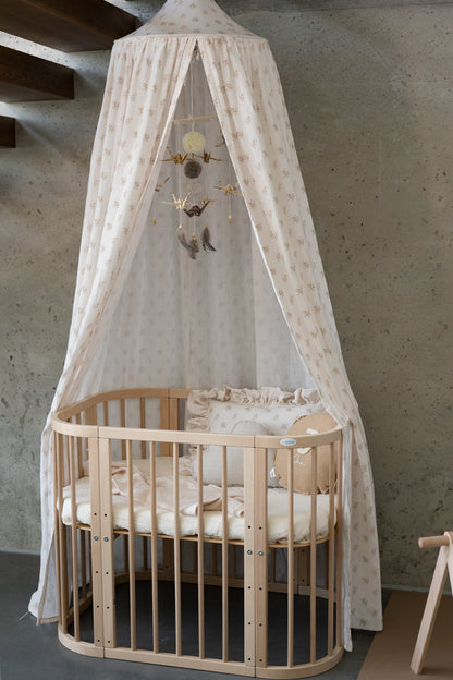 Nursery decor: Gold Dust origami mobile hanging elegantly above a wooden baby crib