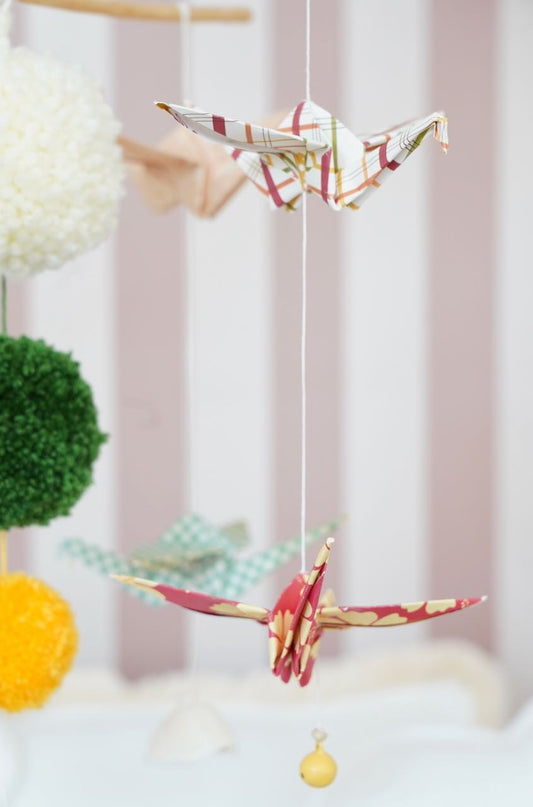 Detailed view of the warm-colored fabric and geometric origami folds of the vintage mobile