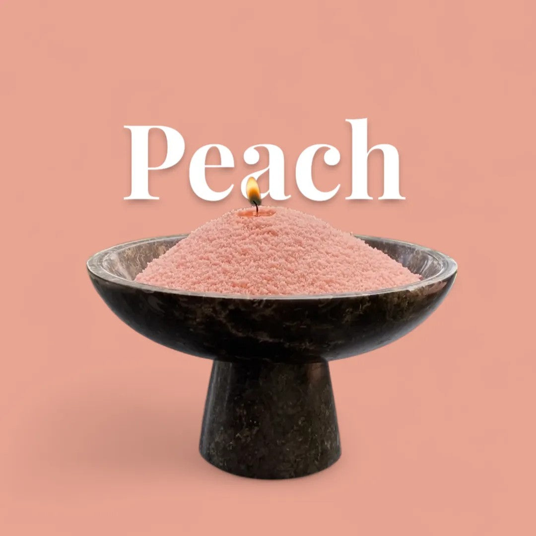 Peach text on a matching warm peach background with a glass vase full of unlit pearled candle sand in the foreground