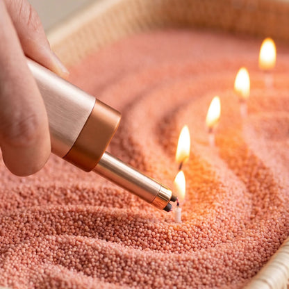 Close-up of a woman's hand lighting the cotton wick of a Peach pearled sand candle