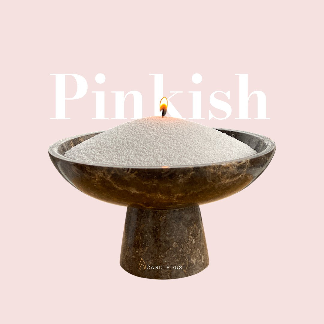 Pinkish text on a matching soft pinkish background with a glass vase full of unlit pearled candle sand in the foreground