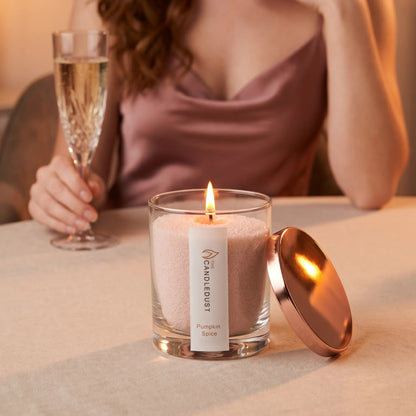 Lit Candledust Pumpkin Spice scented pearled candle in a 160g glass jar in a romantic atmosphere