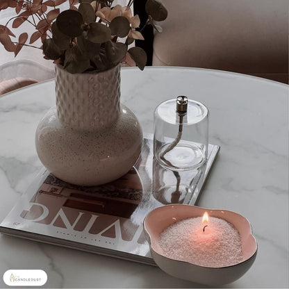 Lit Pumpkin Spice scented pearled sand candle displayed on a decorative tray resting on a coffee table