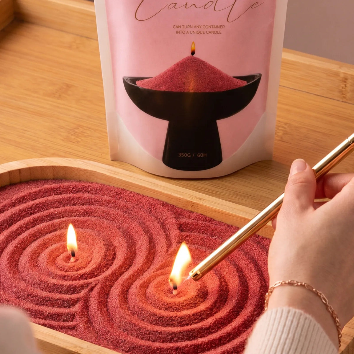 Close-up of a woman's hand lighting the cotton wick of a Red pearled sand candle