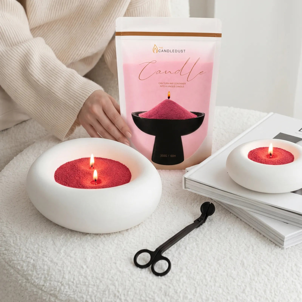 Elegant vase filled with Red pearled candle sand and lit cotton wicks resting on a sofa