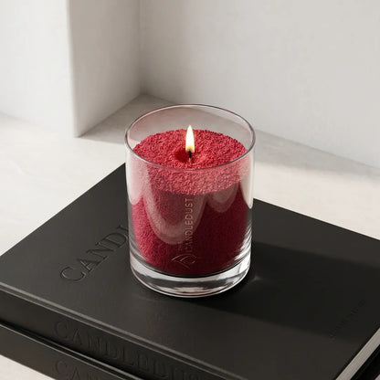 Lit Sangria Red unscented pearled glass candle displayed on stacked black books