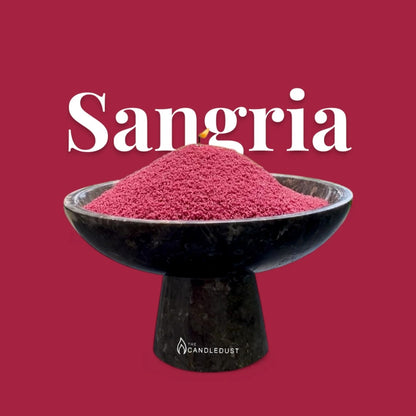 Sangria text on a matching rich sangria red background with a glass vase full of unlit pearled candle sand in the foreground