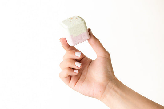 Woman's hand holding a natural CBD shower steamer with essential oils - Lizush Shower Steamers Gift Set
