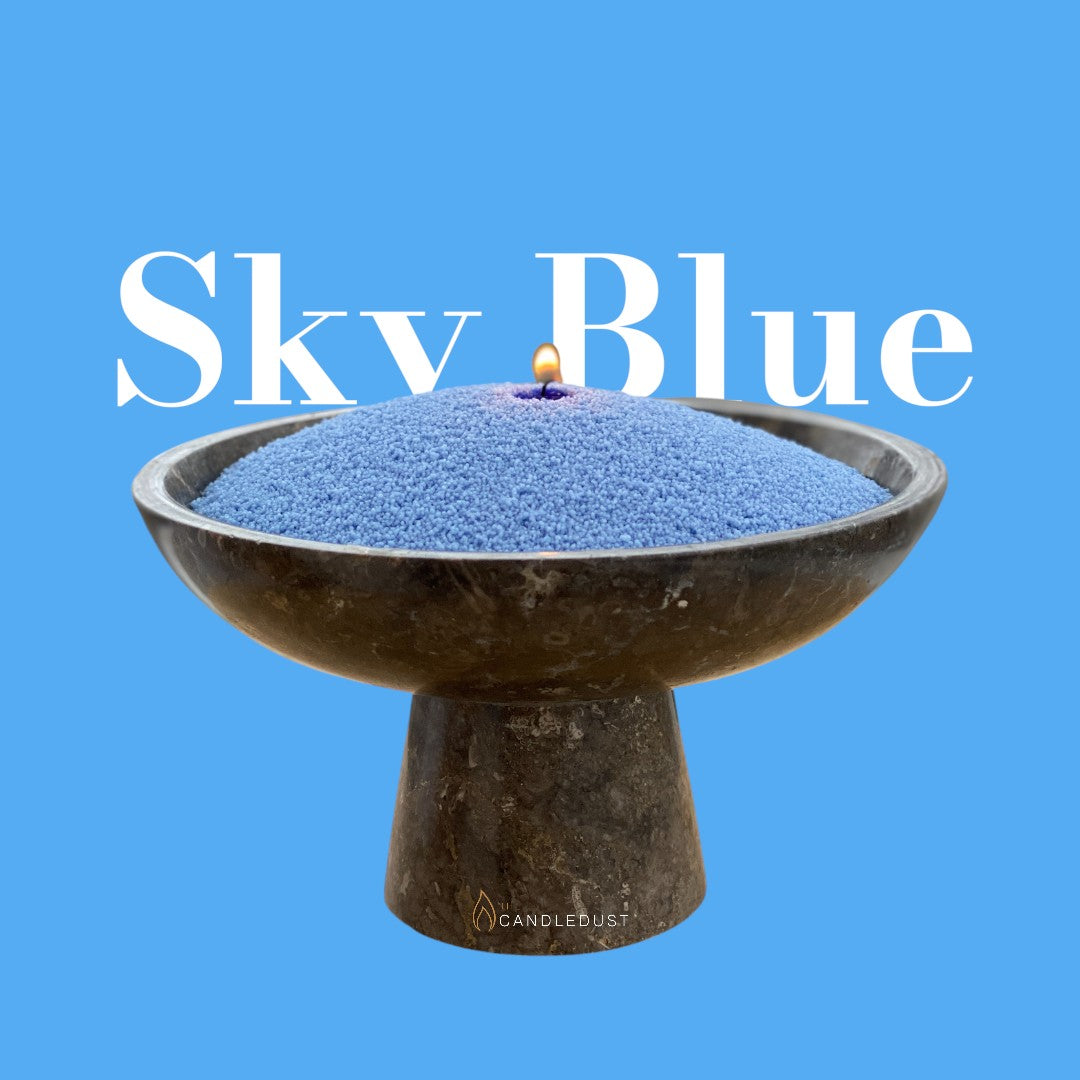 Sky Blue text on a matching serene sky blue background with a glass vase full of unlit pearled candle sand in the foreground
