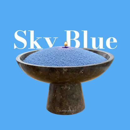 Sky Blue text on a matching serene sky blue background with a glass vase full of unlit pearled candle sand in the foreground