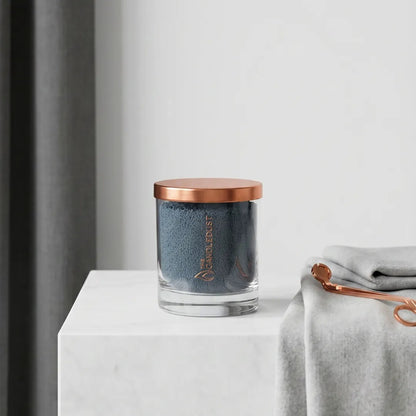 Candledust Space Grey unscented pearled candle in a 160g glass jar sitting on a white marble countertop